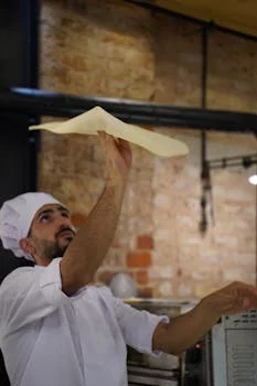pizzaiolo tossing dough skillfully
